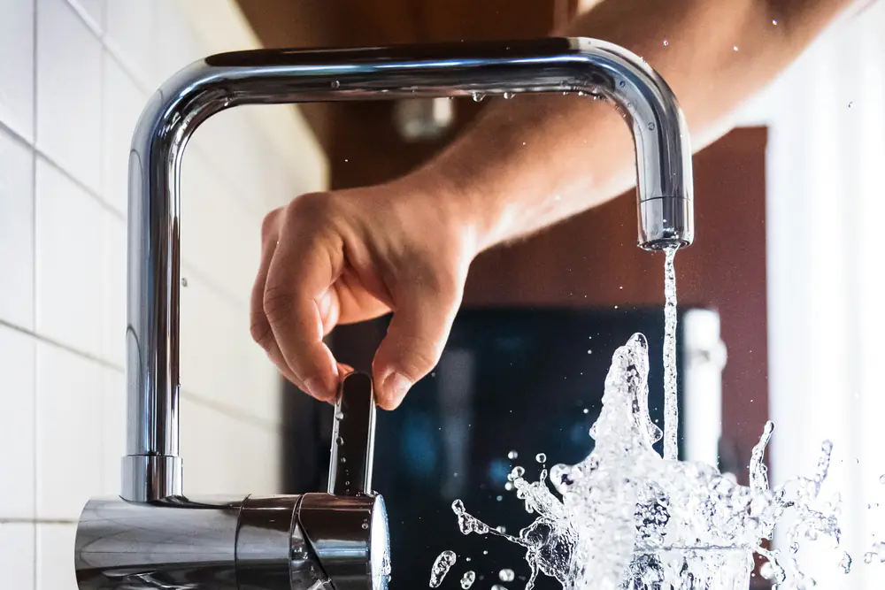 Un mitigeur de cuisine qui remplit un verre d’eau