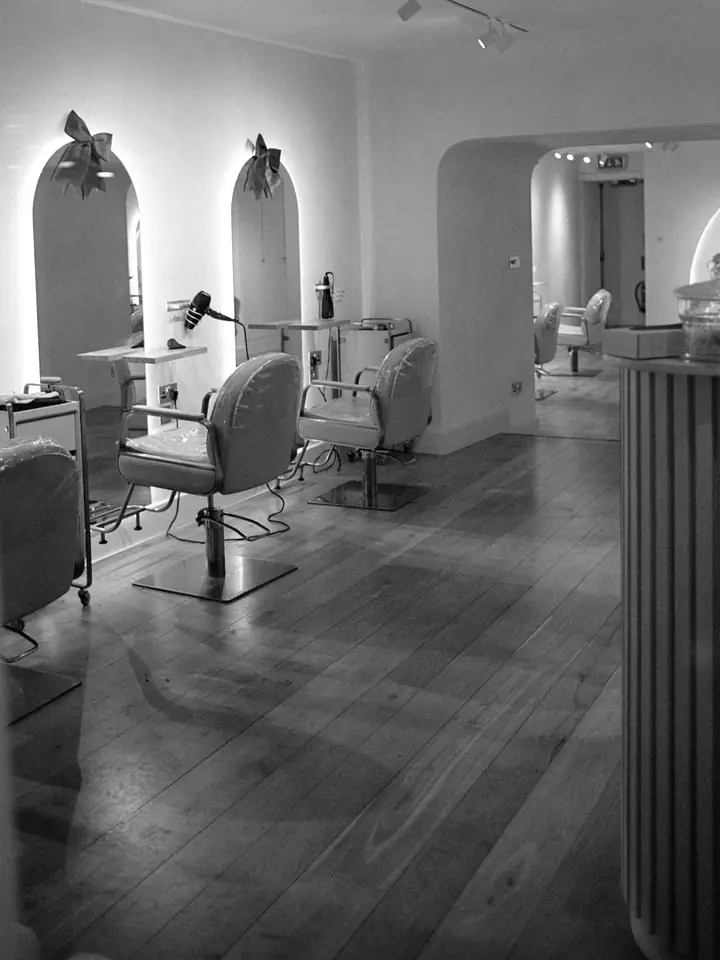 Le salon en noir et blanc : fauteuils, miroirs en arche et parquet