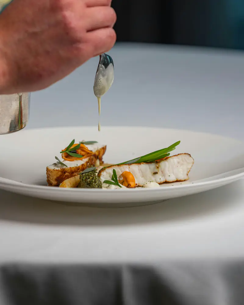 Un filet de poisson nappé de sauce, juste avant le service